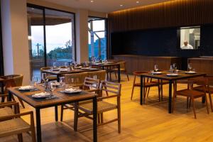 a restaurant with tables and chairs and a large screen at Aurum Hotel in Palasë
