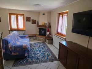 a living room with a couch and a tv at Casa con giardino e garage vicino alle piste in San Pietro