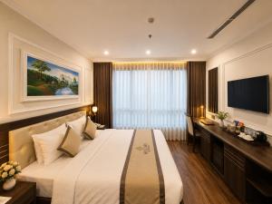 a hotel room with a bed and a flat screen tv at Hillary Hanoi Hotel With Outdoor Swimming Pool in Hanoi