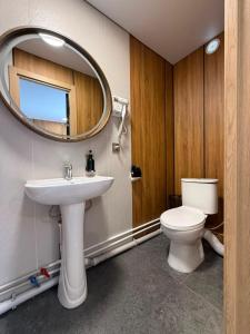 a bathroom with a sink and a mirror and a toilet at GuestHouse-Medeu in Almaty +79 photos