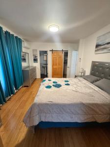a bedroom with a bed and blue curtains at Bright & Comfortable Home in the Heart of It All in Central Islip