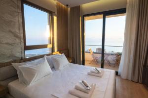 a hotel room with a bed with towels on it at Aurum Hotel in Palasë +228 photos