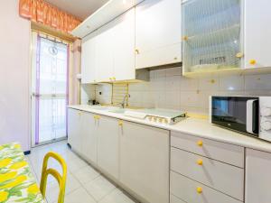 a kitchen with white cabinets and a microwave at La Dolce vista, Lecco apartment with lake view in Malgrate