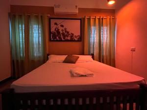 a bedroom with a large bed with a hat on it at Coliveinn in Ernakulam