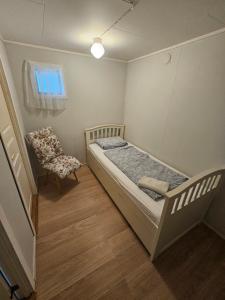 a small bedroom with a bed and a chair at Quiet Valley Tomrefjord in Vestnes
