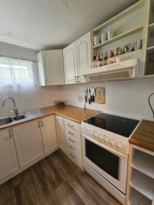 a kitchen with white cabinets and a stove top oven at Quiet Valley Tomrefjord in Vestnes