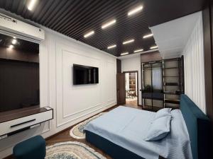 a bedroom with a bed and a flat screen tv at Luxury Comfort Double Room in Bukhara