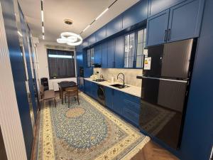 a kitchen with blue cabinets and a sink and a table at Luxury Comfort Double Room in Bukhara