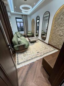 a living room with a green couch and mirrors at Luxury Comfort Double Room in Bukhara