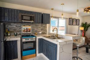 a kitchen with a sink and a stove top oven at Bselifestyle in Green Island