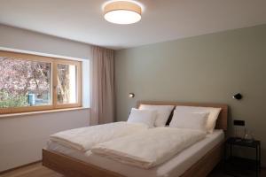 a bedroom with a large bed with a window at Forte Apartments in Klösterle