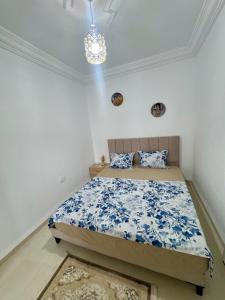 a bedroom with a bed and a chandelier at Le Minaret in Kairouan