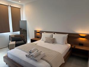a bedroom with a large bed with towels on it at Olympus Stone Lodge in Litochoro