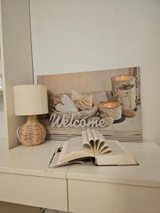an open book on a desk with a lamp and a candle at Quiet Valley Tomrefjord in Vestnes