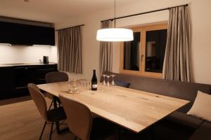 a dining room table with a bottle of wine on it at Forte Apartments in Klösterle +7 photos