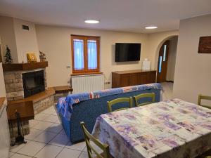 a living room with a table and a tv at Casa con giardino e garage vicino alle piste in San Pietro +22 photos