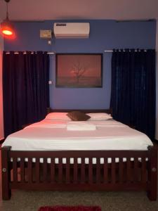 a bed in a bedroom with a blue wall at Coliveinn in Ernakulam