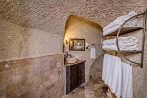 a bathroom with a sink and a toilet and towels at Hidden Cave Hotel in Göreme +137 photos