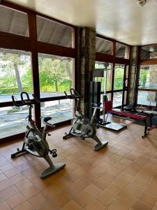 a gym with three exercise bikes in a room with windows at Montana Family Nature in Enveitg +7 photos