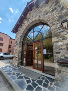 a stone building with a revolving door in front at Montana Family Nature in Enveitg