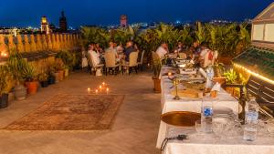 Palais Riad Reda & Spa في فاس: مجموعة من الناس يجلسون على طاولات في فناء ليلاً