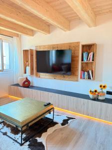a living room with a tv and a coffee table at Maso K La Mucca Rossa in Folgaria