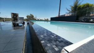a swimming pool with a chair in the middle of it at Hotel Pombeira in Guarda