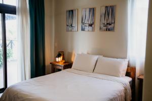 a bedroom with a white bed and a window at Ocean & Lighthouse view apartment in Playa Venao