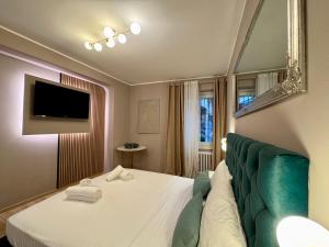 a bedroom with a bed and a couch and a television at Duomo Next Accomodations in Trento