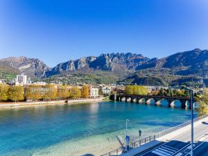 a bridge over a river with mountains in the background at La Dolce vista, Lecco apartment with lake view in Malgrate
