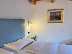 a bedroom with a bed and a picture on the wall at Garnì Stella Alpina in Canazei