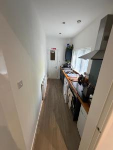 a kitchen with white walls and a wooden floor at Graham Road in Rugby