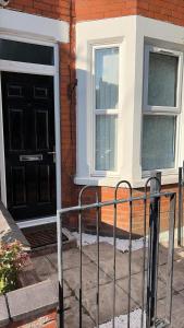 a house with a black door and two windows at Graham Road in Rugby