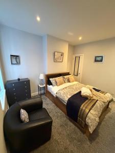 a bedroom with a bed and a chair at Graham Road in Rugby