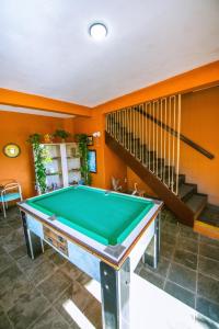 a pool table in a room with orange walls at Pousada Miramar in Marataizes