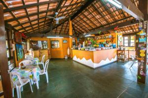 a restaurant with a table and chairs in a room at Pousada Miramar in Marataizes