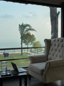 a living room with a couch and a table with a laptop at Baam-E-Noor , Pine Tree Resort , Margalla Hills Islamabad in Harīpur