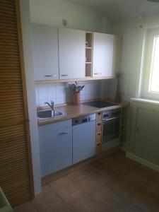 a kitchen with white cabinets and a sink at Blick-ueber-Hohegeiss in Hohegeiß +7 photos