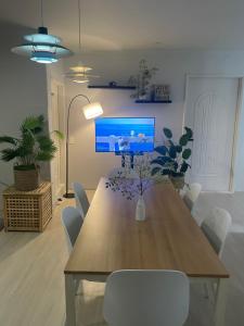 a living room with a table and a tv on the wall at Busan Harbor Stay in Busan