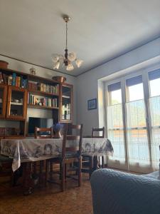 a dining room with a table and chairs and windows at Rifugio Delia in Torre Pellice