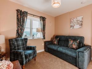 a living room with a couch and a chair at Copper Beech Cottage in Welshpool
