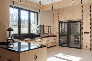 a large kitchen with a counter and a large window at Residence Tatrzański Park in Poronin