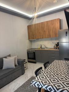 a living room with a couch and a kitchen at Greysuites in Kavála