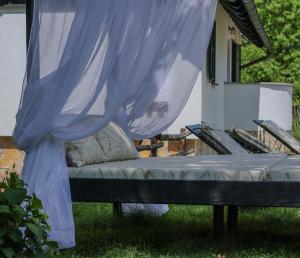 a bed sitting on the grass in front of a house at Etno Garden Apartments in Plitvička Jezera