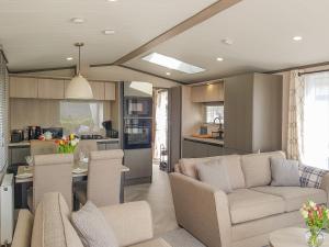 a living room with a couch and a kitchen at Ben Vorlich Lodge in Saint Fillans