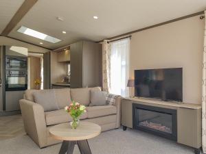 a living room with a couch and a fireplace at Ben Vorlich Lodge in Saint Fillans