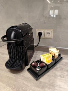 a black coffee maker with a tray of food at Leni's Space in Paralia Katerinis