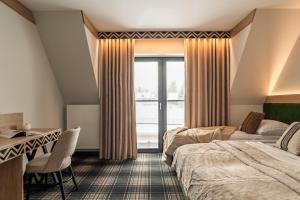 a hotel room with two beds and a desk at Residence Tatrzański Park in Poronin