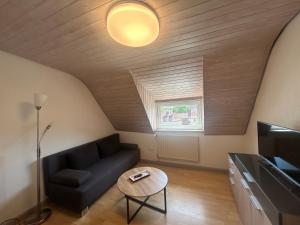 a living room with a couch and a table at Wohnung an der schönen Aue Stadtzentrumsnähe in Fulda