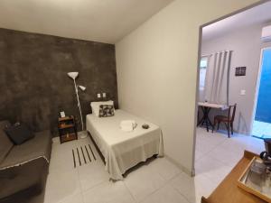 a bedroom with a bed and a table and a couch at Estúdios VILA 5 Hotel, próximo a Praça dos Três Poderes in Brasília